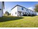Lush green backyard with a white townhouse exterior and a well-maintained lawn at 740 Madison Dr, Davenport, FL 33837