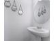 Half bath with stylish wall decor, a round mirror, and a modern pedestal sink at 740 Madison Dr, Davenport, FL 33837