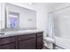 Bright bathroom with a shower-tub combo, vanity with granite countertop and dark wooden cabinets at 740 Madison Dr, Davenport, FL 33837