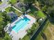 Aerial view of the community pool with lounge chairs, playground, and palm tree landscaping at 740 Madison Dr, Davenport, FL 33837