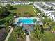 Aerial view of the community pool surrounded by palm trees, lounge chairs, and green lawns at 740 Madison Dr, Davenport, FL 33837