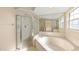 Bright bathroom with a large soaking tub and walk-in shower with glass enclosure at 7431 Sw 129Th Pl, Ocala, FL 34473
