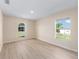 Spacious room with wood flooring, abundant natural light from large windows, and neutral wall color at 7431 Sw 129Th Pl, Ocala, FL 34473