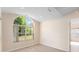 Sunlit bedroom featuring a large arched window, with views of the exterior landscaping at 7431 Sw 129Th Pl, Ocala, FL 34473