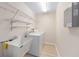 Functional laundry room with sink, washer, dryer, and wire shelving for ample storage at 7431 Sw 129Th Pl, Ocala, FL 34473