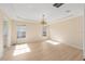 Spacious living room featuring a chandelier, tray ceiling, and bright natural light at 7431 Sw 129Th Pl, Ocala, FL 34473