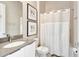 Modern bathroom featuring a toilet and a shower with white curtain, with framed art on the wall at 7740 Sandy Ridge Dr # 236, Reunion, FL 34747