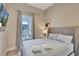 Bright bedroom with a queen-size bed, and a large window at 7740 Sandy Ridge Dr # 236, Reunion, FL 34747
