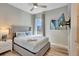 Cozy bedroom with a queen-size bed, ceiling fan, mounted TV, and a window view at 7740 Sandy Ridge Dr # 236, Reunion, FL 34747