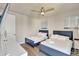 Bright, minimalist bedroom featuring two blue-framed beds, a ceiling fan, and a modern, clean aesthetic at 7740 Sandy Ridge Dr # 236, Reunion, FL 34747