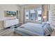 Bright bedroom with a modern dresser, mounted television, and serene neighborhood views at 7740 Sandy Ridge Dr # 236, Reunion, FL 34747