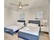Bright bedroom featuring two beds with blue frames and soft white linens, plus stylish wall art at 7740 Sandy Ridge Dr # 236, Reunion, FL 34747