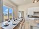 Bright dining area with white table setting, large window and modern kitchen in background at 7740 Sandy Ridge Dr # 236, Reunion, FL 34747