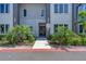 Exterior view of the building entrance surrounded by beautiful landscaping with palm trees and green plants at 7740 Sandy Ridge Dr # 236, Reunion, FL 34747