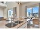 Bright kitchen with white cabinets and stainless steel appliances with view of dining area at 7740 Sandy Ridge Dr # 236, Reunion, FL 34747