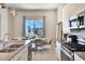 Bright kitchen with white cabinets, stainless steel appliances and dining area in background near large window at 7740 Sandy Ridge Dr # 236, Reunion, FL 34747