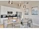 Stylish kitchen with a quartz countertop island, bar stools, stainless steel appliances, and modern pendant lighting at 7740 Sandy Ridge Dr # 236, Reunion, FL 34747