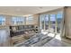 Living room with comfortable gray sofa, coffee table, sliding glass doors to a balcony with table and BBQ at 7740 Sandy Ridge Dr # 236, Reunion, FL 34747
