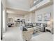 Bright living room with tile floors, a high ceiling, a gray sectional sofa, and modern decor at 7740 Sandy Ridge Dr # 236, Reunion, FL 34747