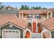 Inviting two-story townhome showcasing a red tile roof, stucco facade, and pedestrian access to upper units at 7806 Sugar Brook Ct # 7806, Orlando, FL 32819
