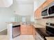 Well-lit kitchen featuring granite countertops, stainless steel appliances, and updated flooring at 7806 Sugar Brook Ct # 7806, Orlando, FL 32819