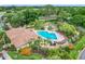 Aerial shot of the community pool with lounge chairs, beautiful landscaping, and nearby neighborhood at 7806 Sugar Brook Ct # 7806, Orlando, FL 32819