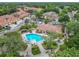 Aerial view of the community pool, surrounded by neighborhood with lush greenery and nearby buildings at 7806 Sugar Brook Ct # 7806, Orlando, FL 32819