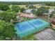 Aerial view of a well-maintained tennis court with nearby playground and surrounding greenery at 7806 Sugar Brook Ct # 7806, Orlando, FL 32819