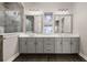 Bathroom boasts dual sinks, a walk-in shower, stone accents, and attractive tile flooring at 7878 Greengard St, Orlando, FL 32827