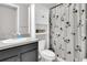 Clean bathroom featuring a vanity with gray countertop, floral shower curtain and built-in storage space at 7878 Greengard St, Orlando, FL 32827