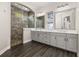 Bathroom boasts dual sinks, a walk-in shower, stone accents, and attractive tile flooring at 7878 Greengard St, Orlando, FL 32827