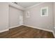 Bright bedroom features wood flooring, white trim, and two windows for ample natural light at 7878 Greengard St, Orlando, FL 32827