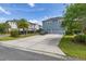 Attractive blue home featuring a two-car garage, landscaping, and a lengthy driveway at 7878 Greengard St, Orlando, FL 32827