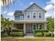 Charming two-story home with a well-manicured lawn, stone accents, and a welcoming covered front porch at 7878 Greengard St, Orlando, FL 32827