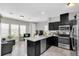 Open-concept kitchen with dark cabinets, stainless appliances, and views of the living area at 7878 Greengard St, Orlando, FL 32827