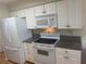 Bright kitchen featuring white cabinets, granite countertops, and modern appliances at 8 Buck Cir # 8, Haines City, FL 33844