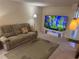 Comfortable living room featuring a plush sofa, a large-screen TV, and warm, inviting lighting at 8 Buck Cir # 8, Haines City, FL 33844