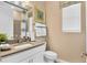 Well-lit half-bathroom with modern vanity, sink, and decorative mirror at 808 Wekiva Ridge Dr, Mount Dora, FL 32757