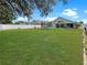 Expansive backyard with lush lawn, trampoline, patio area, and secure white fence at 8439 Adele Rd, Lakeland, FL 33810