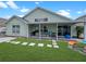 Private backyard with covered patio, bbq, outdoor seating, and lush green lawn at 8439 Adele Rd, Lakeland, FL 33810
