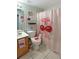 This bathroom has a sink, toilet, and a pink cherry themed shower curtain at 8439 Adele Rd, Lakeland, FL 33810