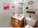 This bathroom features cherry themed decor, a mirror, sink and toilet at 8439 Adele Rd, Lakeland, FL 33810