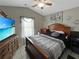Bedroom featuring a wooden bed, natural light, TV, ceiling fan, and tile floors at 8439 Adele Rd, Lakeland, FL 33810