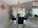 Elegant dining area with a glass-top table, stylish black chairs, and views of the backyard at 8439 Adele Rd, Lakeland, FL 33810