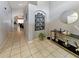 Long hallway with tile flooring, decorative wall art, and a view into other living spaces at 8439 Adele Rd, Lakeland, FL 33810