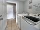 This laundry room features a washer and dryer and decorative laundry themed art at 8439 Adele Rd, Lakeland, FL 33810