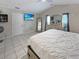 Spacious main bedroom with tiled floor, ensuite, television, and a large window with natural light at 8439 Adele Rd, Lakeland, FL 33810