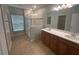 Bright bathroom featuring a glass shower and a double vanity with wood cabinets at 878 Benjamin Trl, Davenport, FL 33837