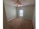 Cozy bedroom with neutral carpet, a ceiling fan, and a window providing natural light at 878 Benjamin Trl, Davenport, FL 33837