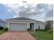 Charming single-story home with a well-manicured lawn and beautiful brick paved driveway at 878 Benjamin Trl, Davenport, FL 33837